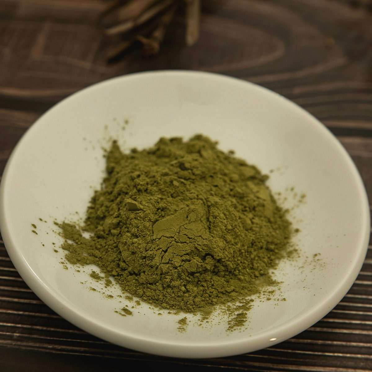Bacopa monnieri extract, a green to greenish-brown powder in a pale dish