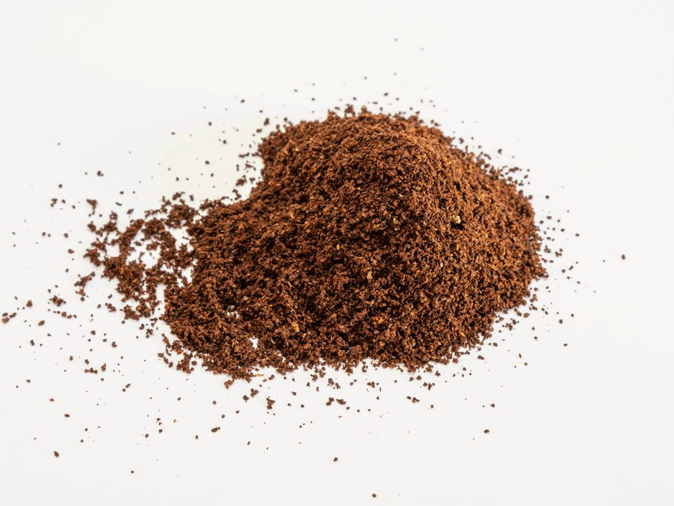 Shilajit powder, a dark brown powder heaped on a white surface