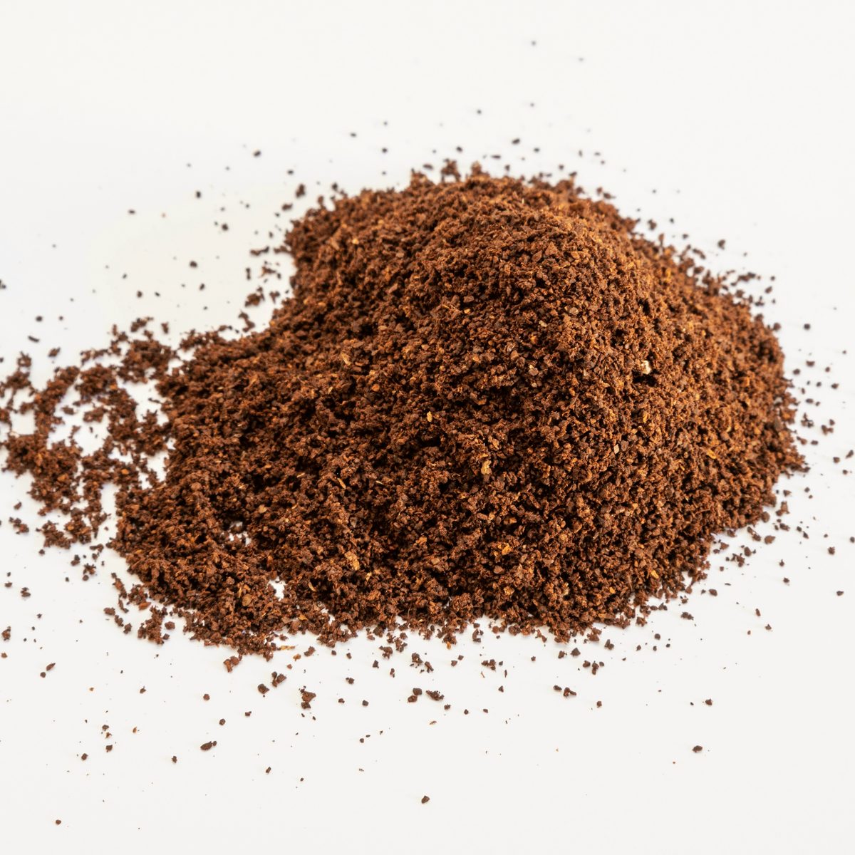 Shilajit powder, a dark brown powder heaped on a white surface